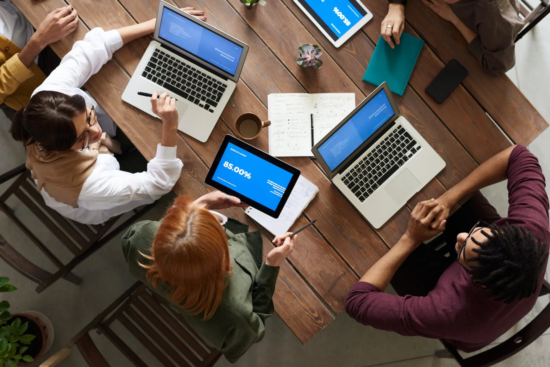 pexels-photo-3182773 top view photo of group of people using macbook while discussing